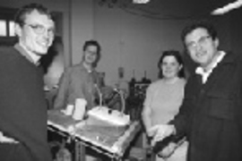 Gathered around the table they developed to test and predict the stability of concrete over long periods of time are (left to right) postdoc Marc Mainguy; graduate student Franz Heukamp; Jennifer Butz, a junior in civil engineering; and Professor Franz Ulm. Concrete samples are treated on this seesawing table, immersed in the container at right. To the left are examples of concrete before immersio...