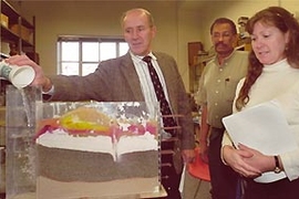 Left to right: Peter Lavelle, a grades 4-8 computer science teacher at the Pierce School in Brookline; Mohamud Yousuf, who teaches children ages 14-17 at Community Solutions Inc. in Roxbury for the Department of Youth Services; and Laura LaBrie, a kindergarten teacher in Holliston Public Schools, show how water moves through the model they constructed of a cross-section of soils beneath a small fa...