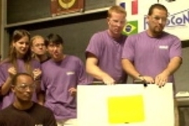 While their teammates root at left, Lilac Team members Peter Weimann  of Germany, left, and Eric Dominguez of the USA concentrate on guiding their machine.