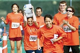 Johnson Games competitors take a shot at "The Balancing Act" on        Saturday. Participants loaded books one-by-one onto their heads, ran a short        distance and then passed them to the next member of their team.