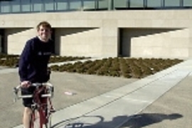 Cancer survivor Kyle Rattray stands next to his bike outside the Zesiger Center. He and a friend will be riding their bikes from Boston to Seattle this summer to raise money for the American Cancer Society.