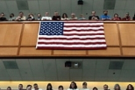 Lincoln Lab employees gaze down as U.S. Rep. John Tierney (center), flanked by Rep. Marty Meehan (left) and U.S. Sen. Edward Kennedy, speaks at a panel highlighting the regional collaboration between the academic, military and private sectors.