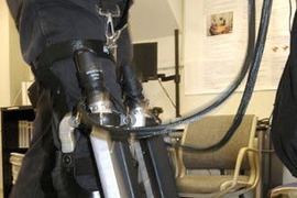 Hermano Igo Krebs, a principal research scientist in MIT's mechanical engineering department, takes the Anklebot for a test walk on a treadmill June 24 at MIT's Newman Laboratory for Biomechanics and Human Rehabilitation.