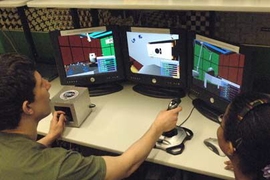 An aeronautics and astronautics project led by MIT researcher Chuck Oman aims to provide better training systems for astronauts to learn how to use robotic arms in space. At left, Joseph Silverman, a sophomore in mechanical engineering, tries his hand with the joysticks that control the robotic arm. At right is graduate student Zakiya Tomlinson, who is running the experiment.