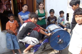 MIT students and residents of Ventanilla, Peru work on the bicilavadora, a novel, inexpensive bike/washing machine.