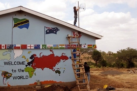 Esther Jang mounts a directional WiFi antenna on the roof of the computer room/science lab building at Orkeeswa Secondary School in Tanzania.