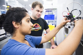 Ginkgo Bioworks staff members Ramya Prathuri (left) and Nate Tedford work at the mass spectrometer in the Ginkgo foundry.
