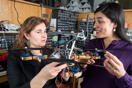 Researchers including MIT professor Daniela Rus (left) and research scientist Stephanie Gil (right) have developed a technique for preventing malicious hackers from commandeering robot teams’ communication networks. To verify the theoretical predictions, the researchers implemented their system using a battery of distributed Wi-Fi transmitters and an autonomous helicopter.
