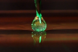 Visualization of vortices in a drop of silicone oil sitting on a warm bath. The temperature difference generates a recirculating flow that is visualized by shining a green laser light on fluorescent particles that are added as passive tracers within the drop.