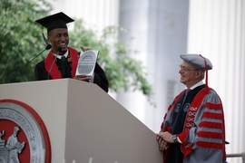 Colin Webb, president of the graduating senior class, presented President Reif with a copy of a plaque that will adorn the lobby of MIT’s newest building, MIT.nano. The 6-inch-diameter silicon wafer has the names of all 200,000 MIT graduates and faculty through its entire history, etched in microscopic type to form an image of MIT’s Great Dome.