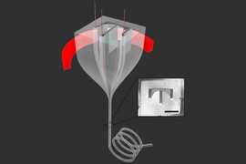 Drawing illustrates the way a larger “preform” (at top) is heated in a furnace (with the heating element shown in red), and then is drawn through a narrow opening to form a fiber that retains the shapes created in the preform, but at a greatly reduced size. Inset shows the pattern of channels inside the fiber.