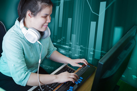 blind woman with headphones who is typing on a braille keyboard