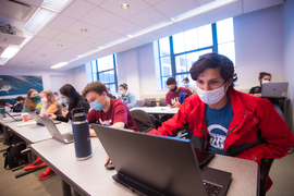 Andres Arroyo in a classroom on computer