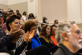 Photo shows the audience smiling and clapping.