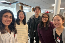 5 people smile and pose together for a photo indoors while wearing Boston Medical Center badges.