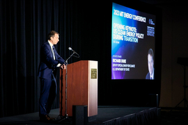 Richard Duke stands at a podium with a screen in background that says, “2023 Energy Conference. Opening Keynote: US Clean Energy Policy During Transition.”