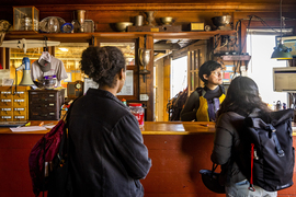 2 community members sign in at the front desk inside the beautiful, wooden building adorned with trophies and memorabilia.