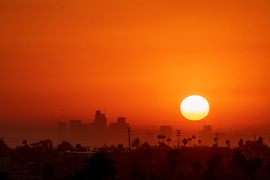 Yellow sun and orange sky over skyline.