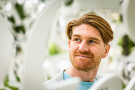 Jackson Jewett smiles inside Jaume Plensa’s Alchemist, 2010, a white sculpture made of latticed numbers.