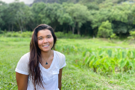 Aja Grande poses for portrait surrounded by tropical greenery.