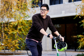 Portrait of David Hsu outside, with yellow foliage in background.