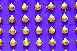 A colorized microscopic view shows the cone-shaped microneedles laid on out a grid, in yellow, on a purple surface.