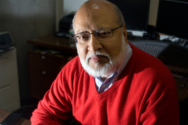 Arvind sits in chair for portrait