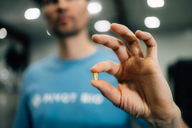 A person holds up a corn kernel.