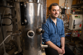 Daniel Suess in the lab next to equipment.